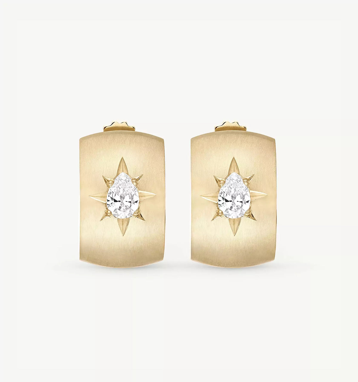 Gold earrings featuring a pear-shaped diamond set in a starburst design.