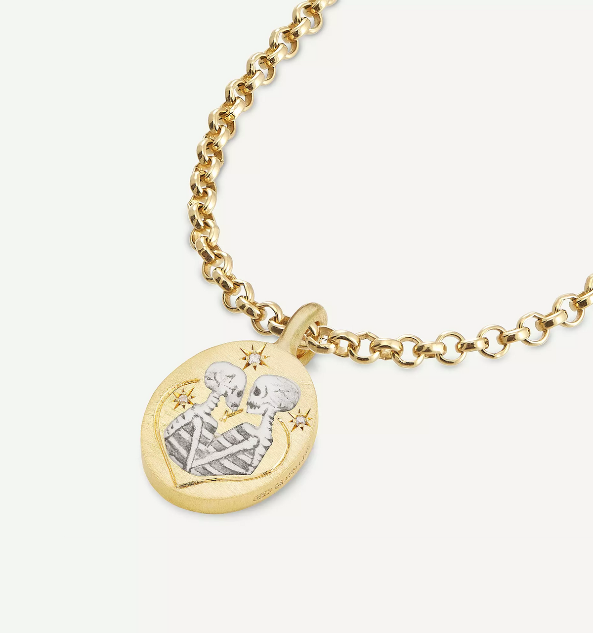 Gold pendant featuring an engraved design of two skeletons with stars on a delicate gold chain.