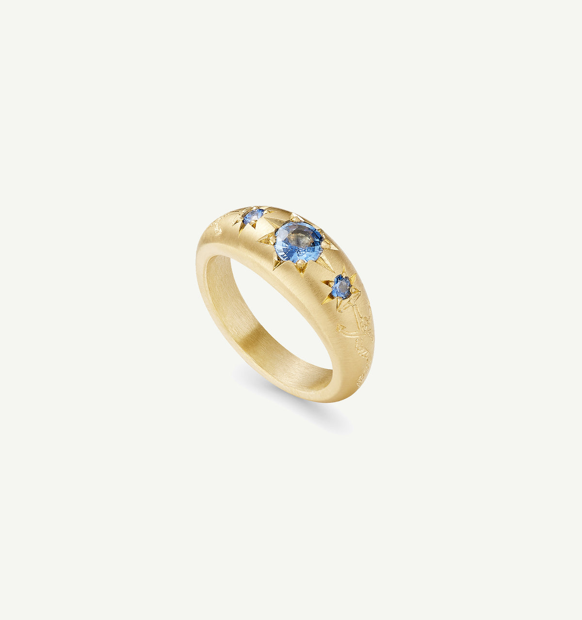 Gold ring featuring blue sapphires with star motifs.