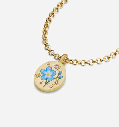 Gold pendant necklace featuring blue floral enamel design and star motifs.