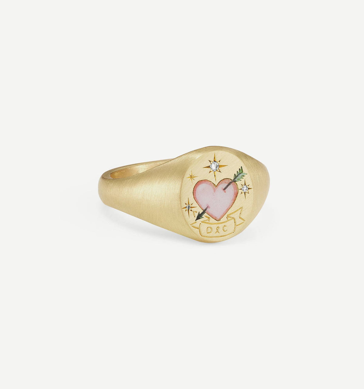Gold ring featuring a pink heart motif with an arrow, embellished with two small diamonds and decorative engraving.
