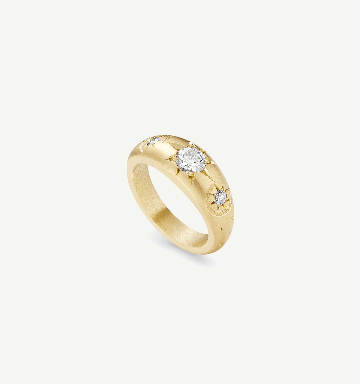 Gold ring with a central diamond and engraved star motifs on a matte finish.