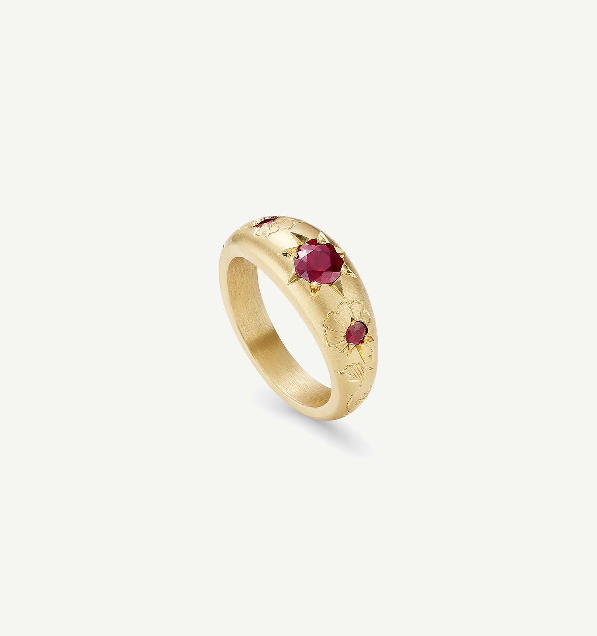 Gold ring featuring engraved floral designs and red rubies.