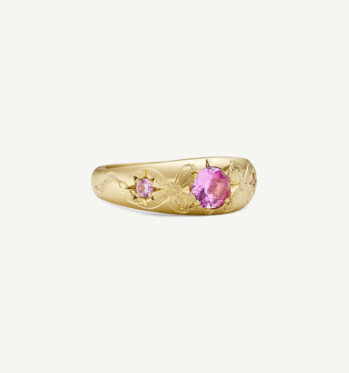 Gold ring featuring engraved floral motifs and pink sapphires.