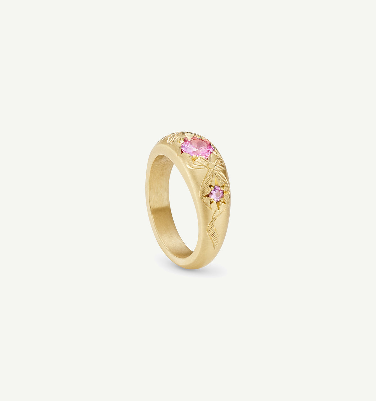 Gold ring featuring pink sapphires and intricate engraving of floral motifs.